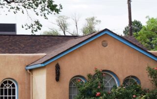 A mixed style, part territorial part phuble style home with tan stucco and blie trim on Monte Vista Blved in Albuquerque's University District